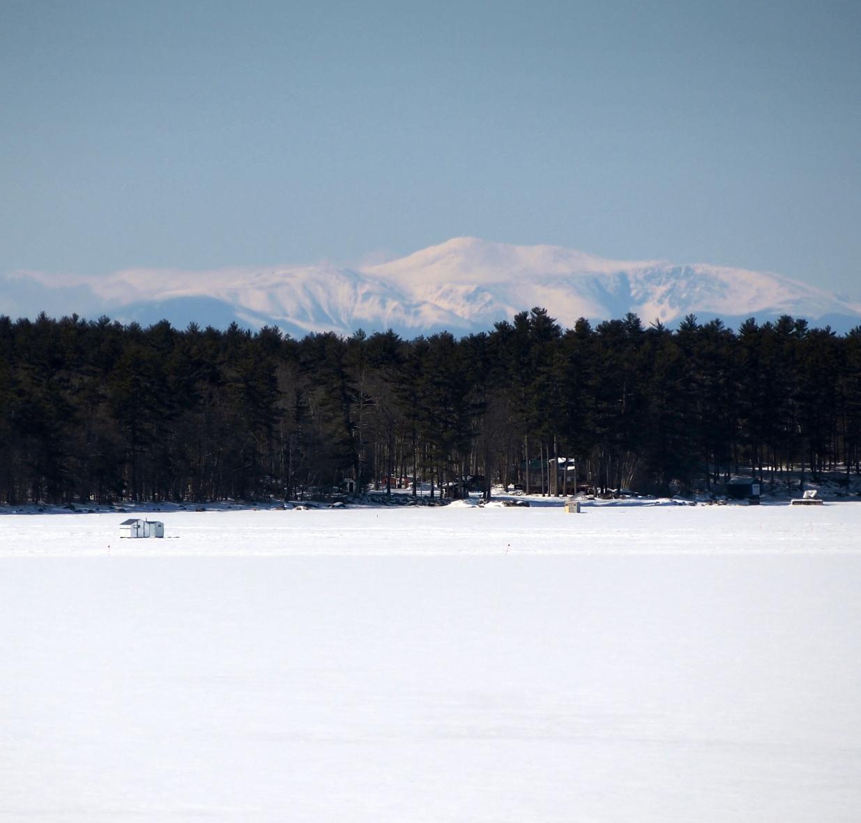 Open field covered with snow, trees in background